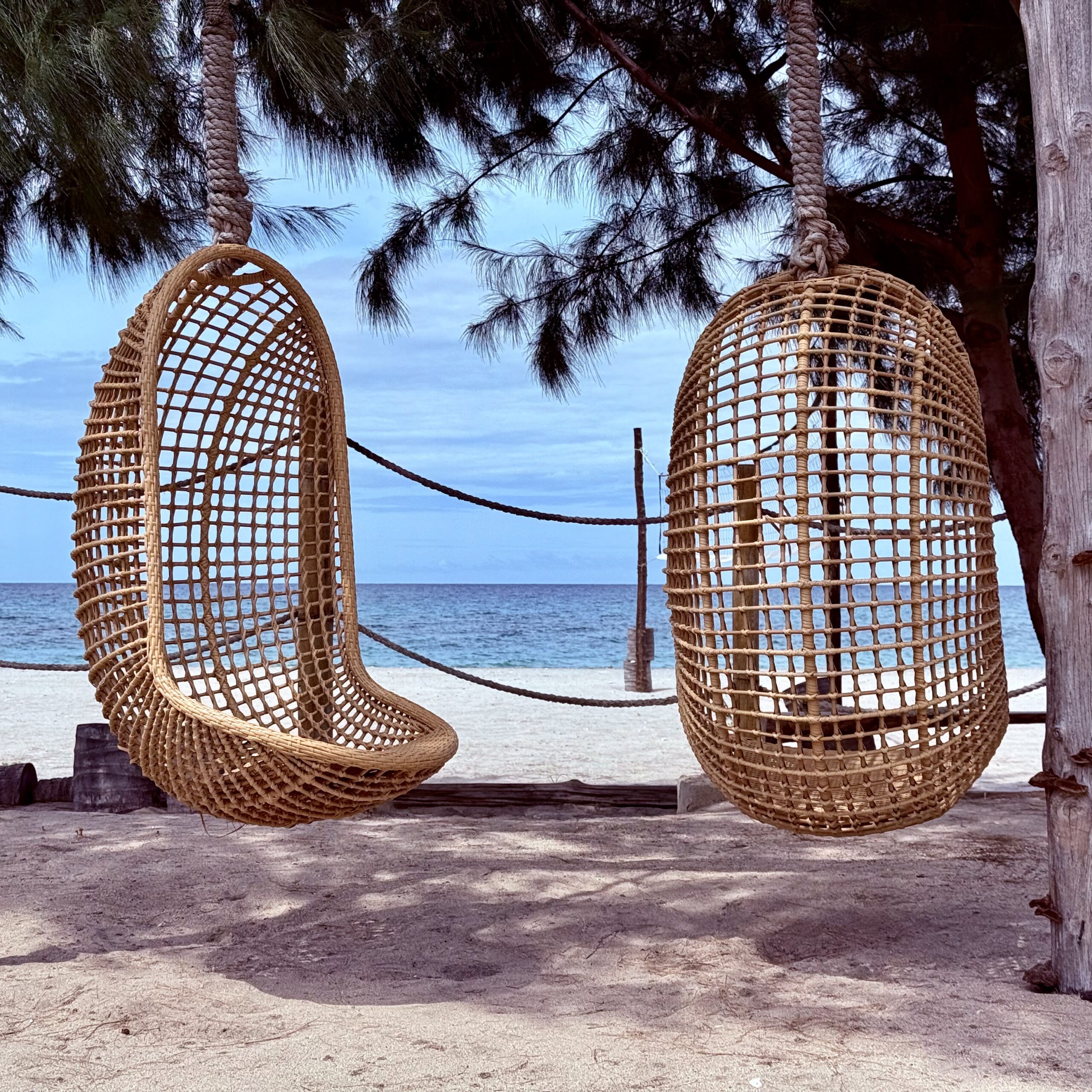 Balancelles en bois face à la mer à Sumba, sous l'ombre des arbres