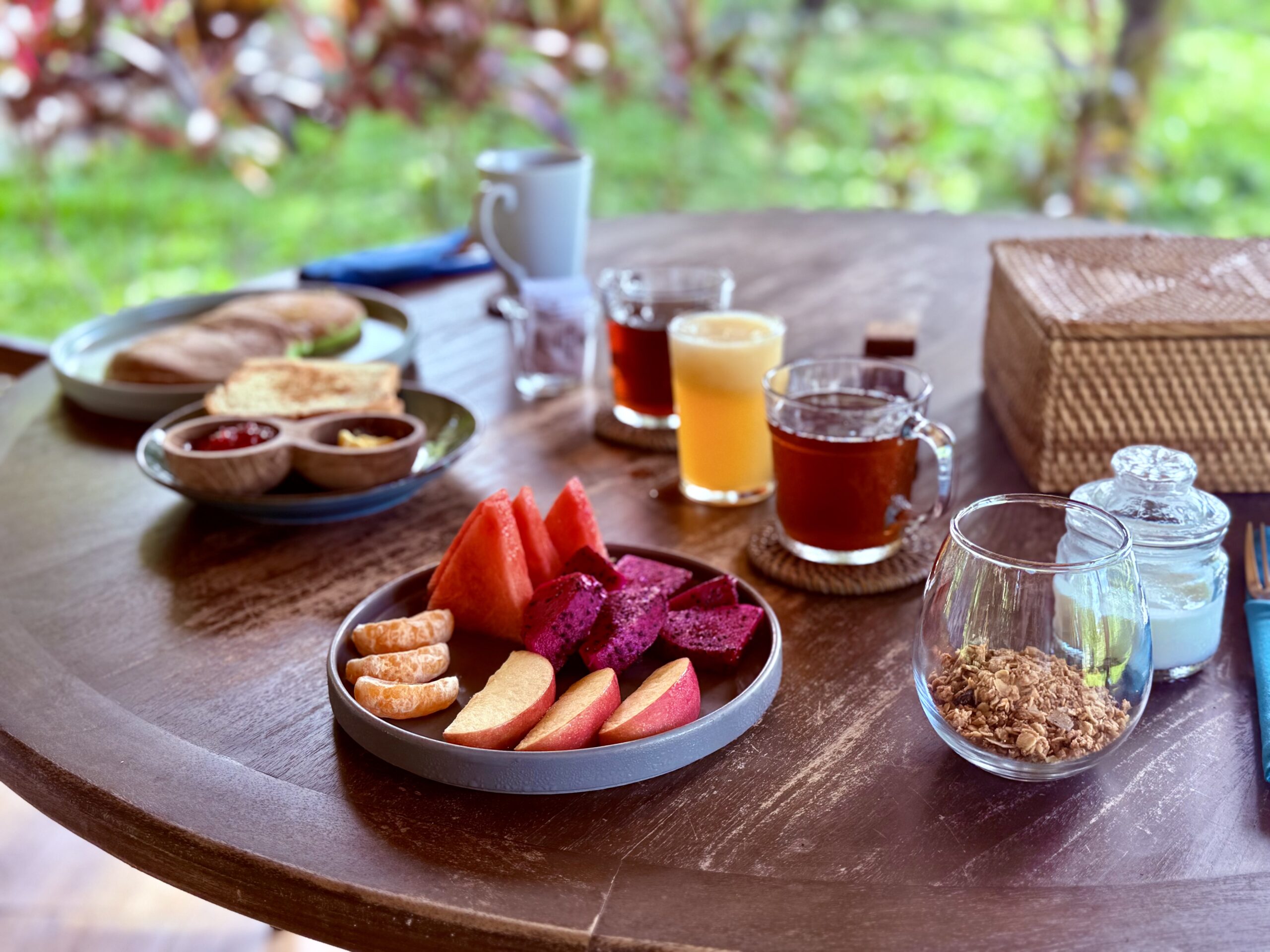 Assiette de fruits frais tropicaux et boissons sur une table en bois à Sumba.